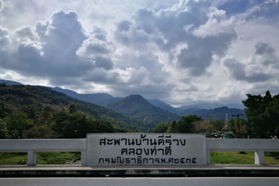 Information sign on railing against sky