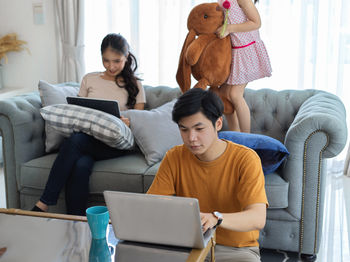 Couple using laptop while sitting at home