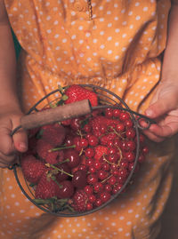 Midsection of woman holding strawberry