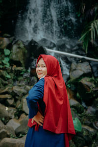 Rear view of smiling girl standing on land