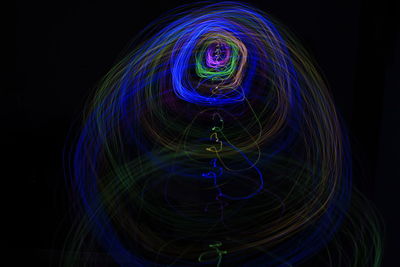 Close-up of light painting against black background using long exposure 