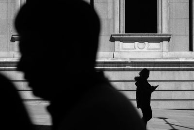 Rear view of silhouette people walking on zebra crossing