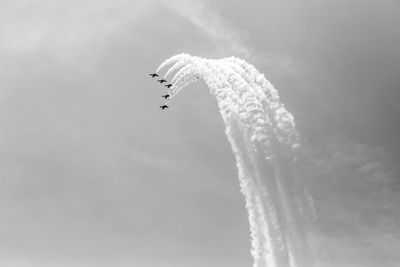 Low angle view of airplane flying against sky airshow