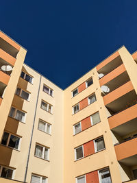 Low angle view of buildings against clear blue sky