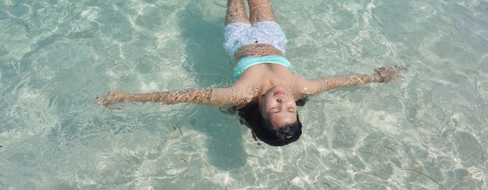 High angle view of happy girl swimming in pool