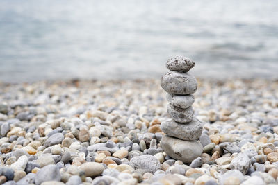 Pyramid of pebbles on the sea beach.waves in background