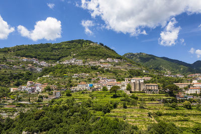 Scenic view of townscape and mountains against sky