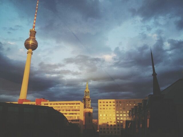 architecture, building exterior, built structure, tower, sky, communications tower, cloud - sky, spire, tall - high, city, famous place, travel destinations, international landmark, capital cities, tourism, cloudy, television tower, travel, fernsehturm, religion