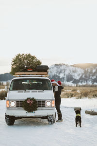 Couple takes a break from driving roadside kiss during holidays christmas tree