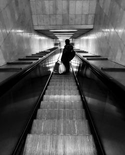 Rear view of man on escalator