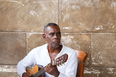 Cuban musician playing the guitar in havana - cuba