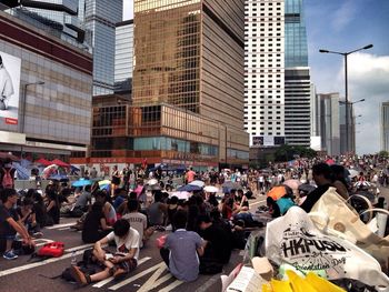 Group of people on street against buildings in city