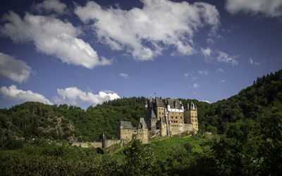 Old building by mountains against sky