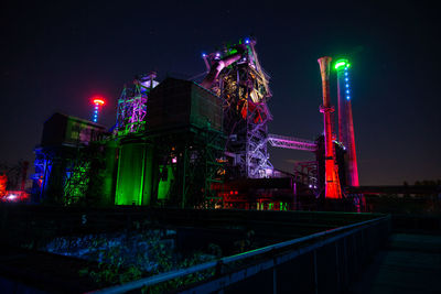 Low angle view of illuminated building against sky at night