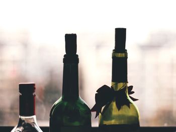 Close-up of wine bottles against window