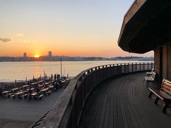 Pier over sea against sky during sunset