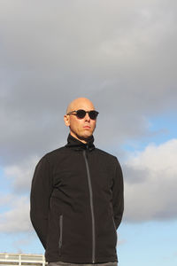 Portrait of young man standing against sky