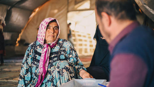 An elderly woman receives medical care at a makeshift medical clinic inside a syrian refugee camp.