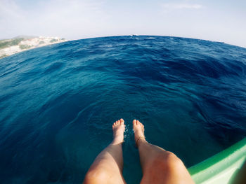 Low section of man in sea against sky