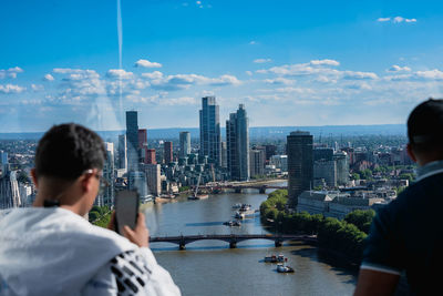 Rear view of man looking at river in city