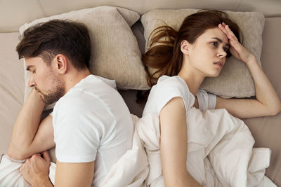 Young couple lying on sofa at home