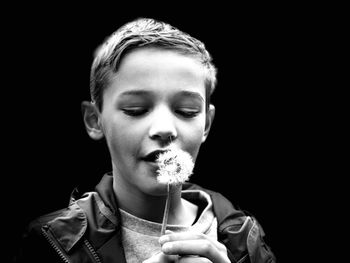 Portrait of cute boy holding black background