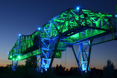 Low angle view of illuminated industrial metallic structure