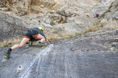 Young woman climbing on rock