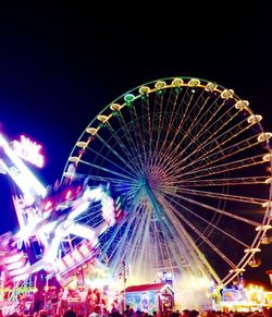 Low angle view of illuminated ferris wheel at night