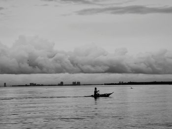 Man on boat in sea against sky