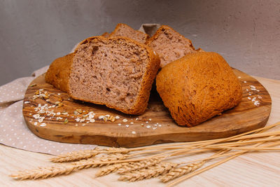 Home-baked bread sliced on a wooden board decorated with spikelet and wheat