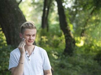 Happy boy smiling against trees