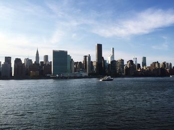 Boats in river with city in background