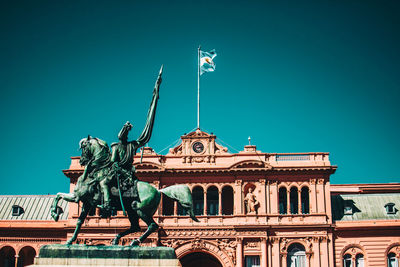 Low angle view of statue against blue sky