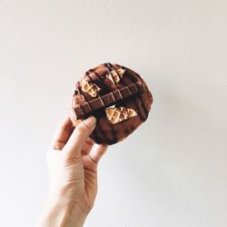 Person holding doughnut against white background