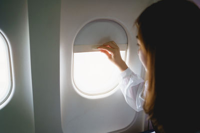 Rear view of woman looking through window