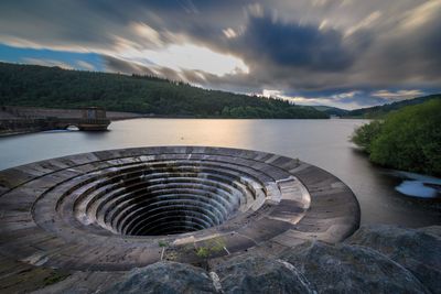 Dam against cloudy sky in lake