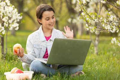 Smiling girl talking on video conference at park