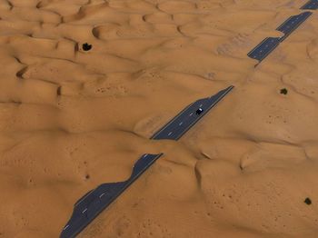 High angle view of road and a car covered with sand 