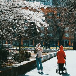 Woman on snow covered plants against trees