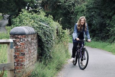 Young woman riding bicycle in park