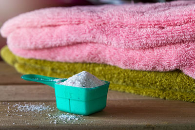 Close-up of laundry detergent with towels on table