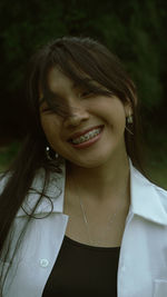 Close-up of smiling young woman with eyes closed