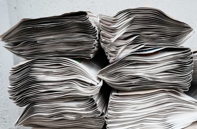 Close-up of stack of papers over white background