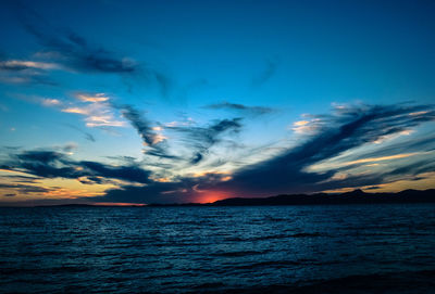 Scenic view of sea against dramatic sky during sunset