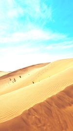 Sand dunes in desert against sky