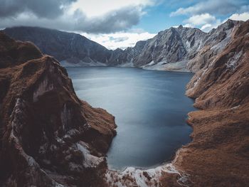 Scenic view of sea and mountains against sky