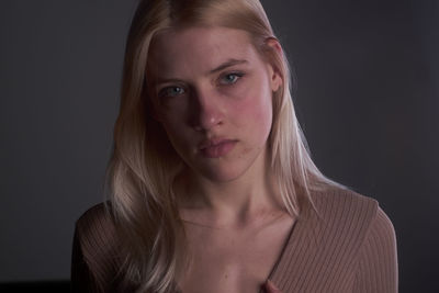 Portrait of woman against black background