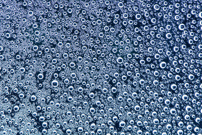 Close-up of water drops on blue glass