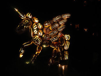 Close-up of illuminated statue against black background